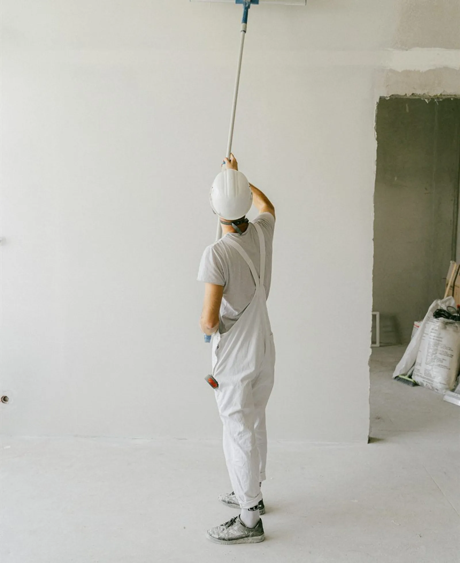 Interior wall being painted with a roller after room preparation